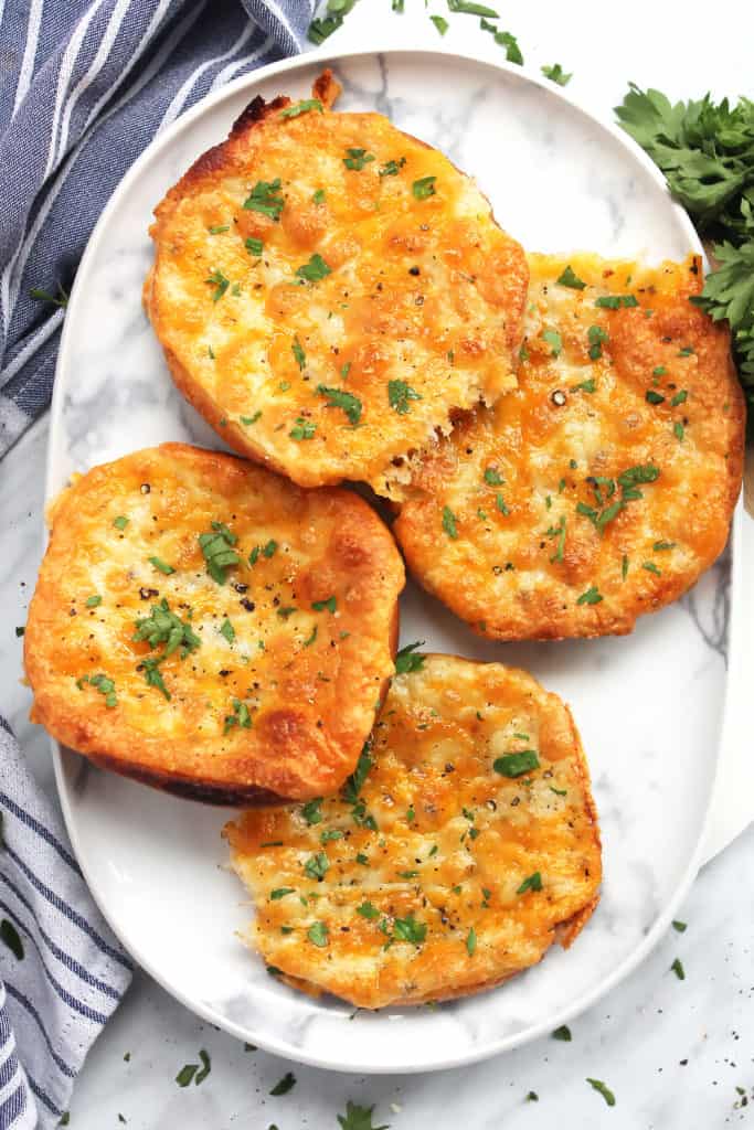 Four slices of cheesy garlic bread on a plate