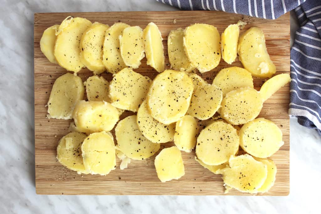 Sliced potatoes seasoned with salt and pepper before being fried