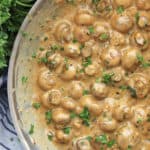 Close up of creamy garlic mushrooms ready to serve garnished with fresh parsley