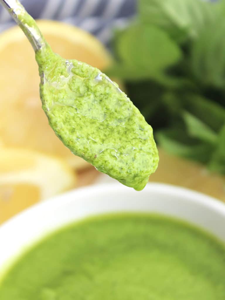 The pesto on a small spoon