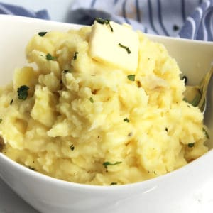 A pat of butter melting on top of the mashed potatoes.