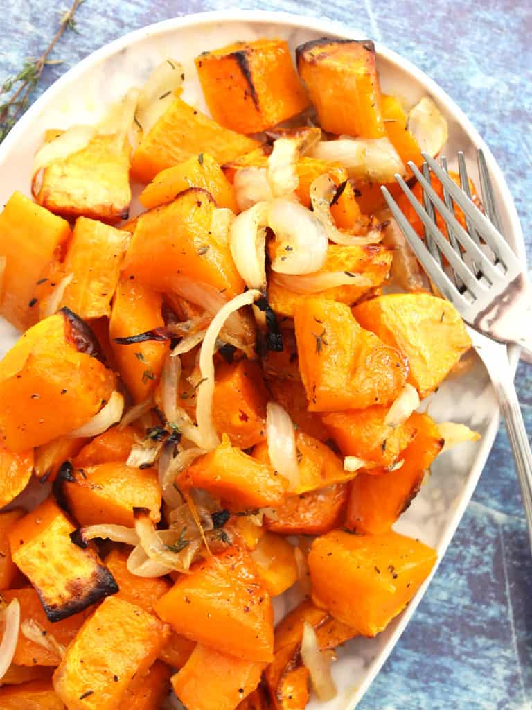 Maple roasted butternut squash on a white plate with two forks.