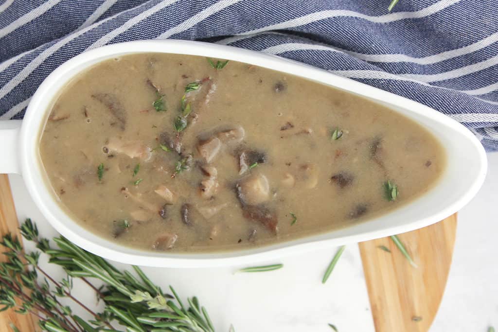 Mushroom gravy served in a boat and garnished with thyme leaves.