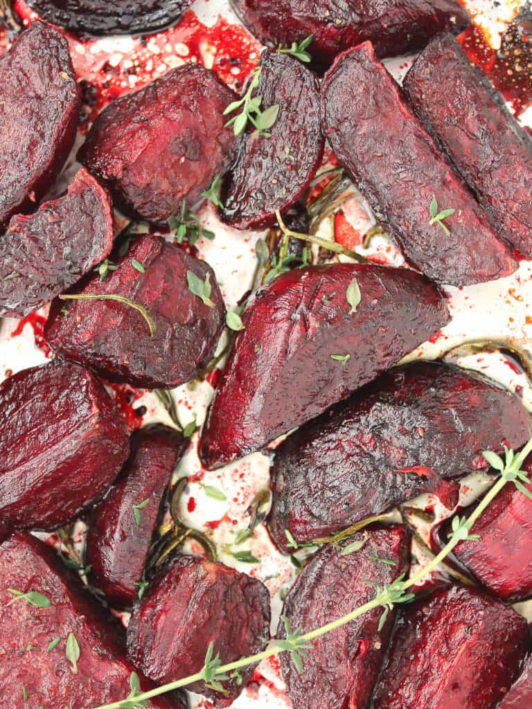 Roasted beet wedges on foil with fresh sprigs of thyme.