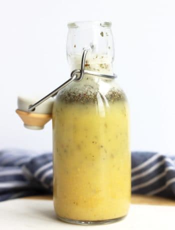 Apple cider and mustard vinaigrette in a glass bottle with a stopper.