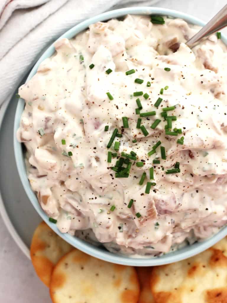 Red onion dip garnished with fresh chives.
