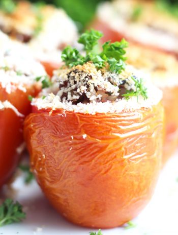 Close up of a wild rice stuffed tomato garnished with chopped parsley.