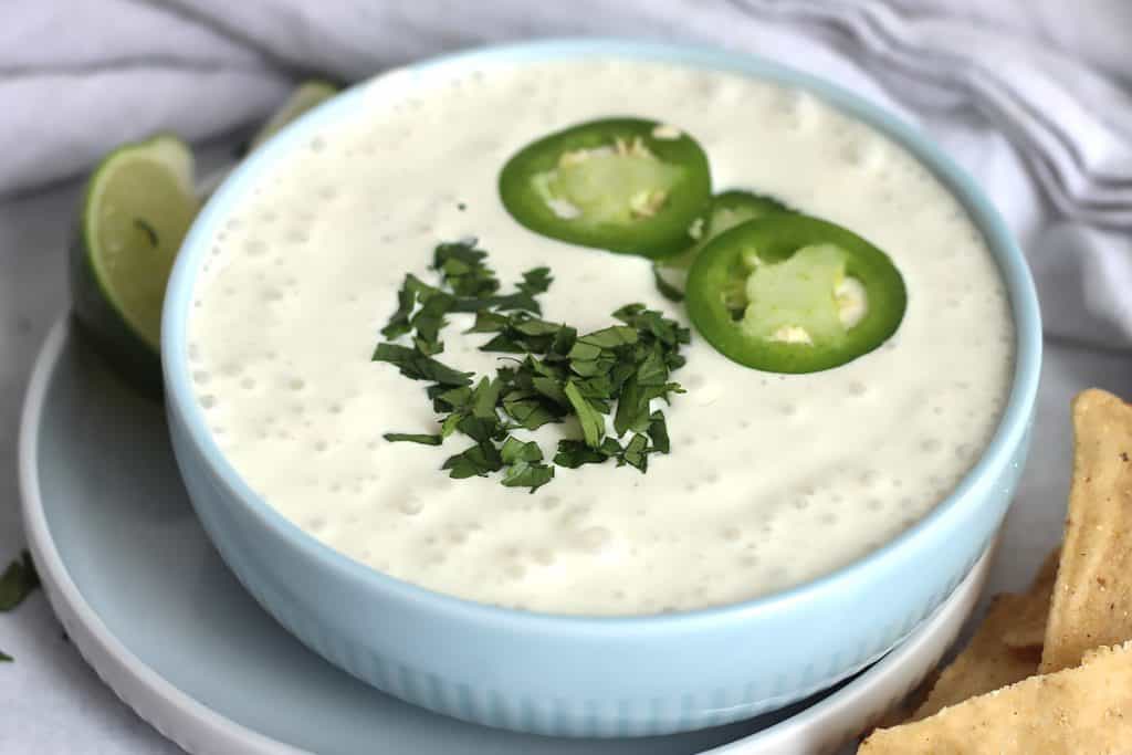 Jalapeno sour cream in a small blue bowl.