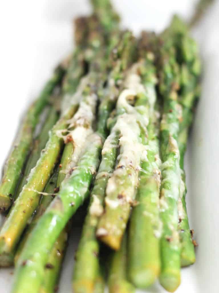 Close up of the melted cheese on the cooked asparagus spears.