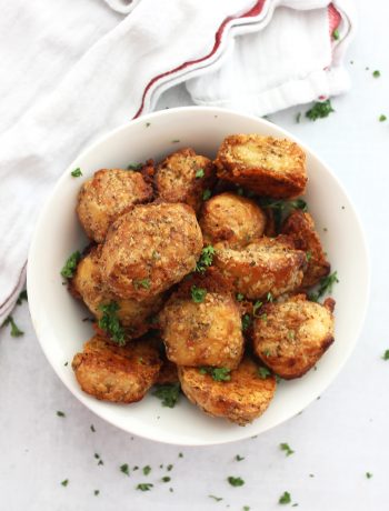Parmesan crusted roasted potatoes in a white bowl.