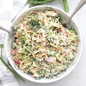 Broccolini coleslaw in a serving bowl with two spoons.