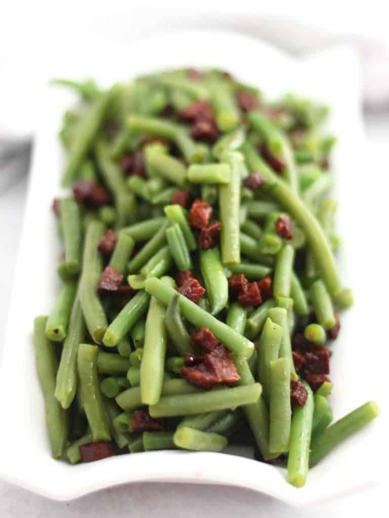 Green beans served with cooked diced chorizo.