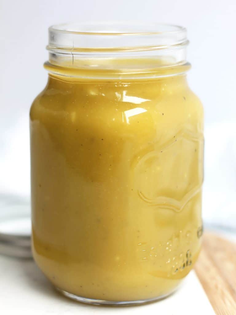 A mason jar with the maple dijon mustard salad dressing in it.
