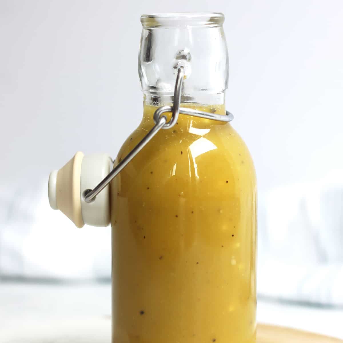 A glass bottle with maple mustard salad dressing.