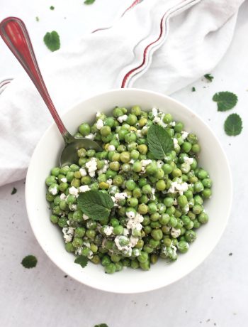 Pea mint and feta salad in a white bowl with a spoon.