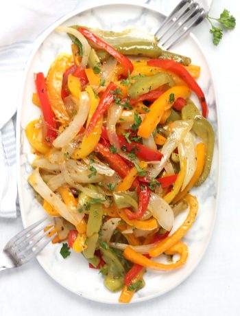 Overhead shot of sautéed peppers and onions on a plate with two forks.