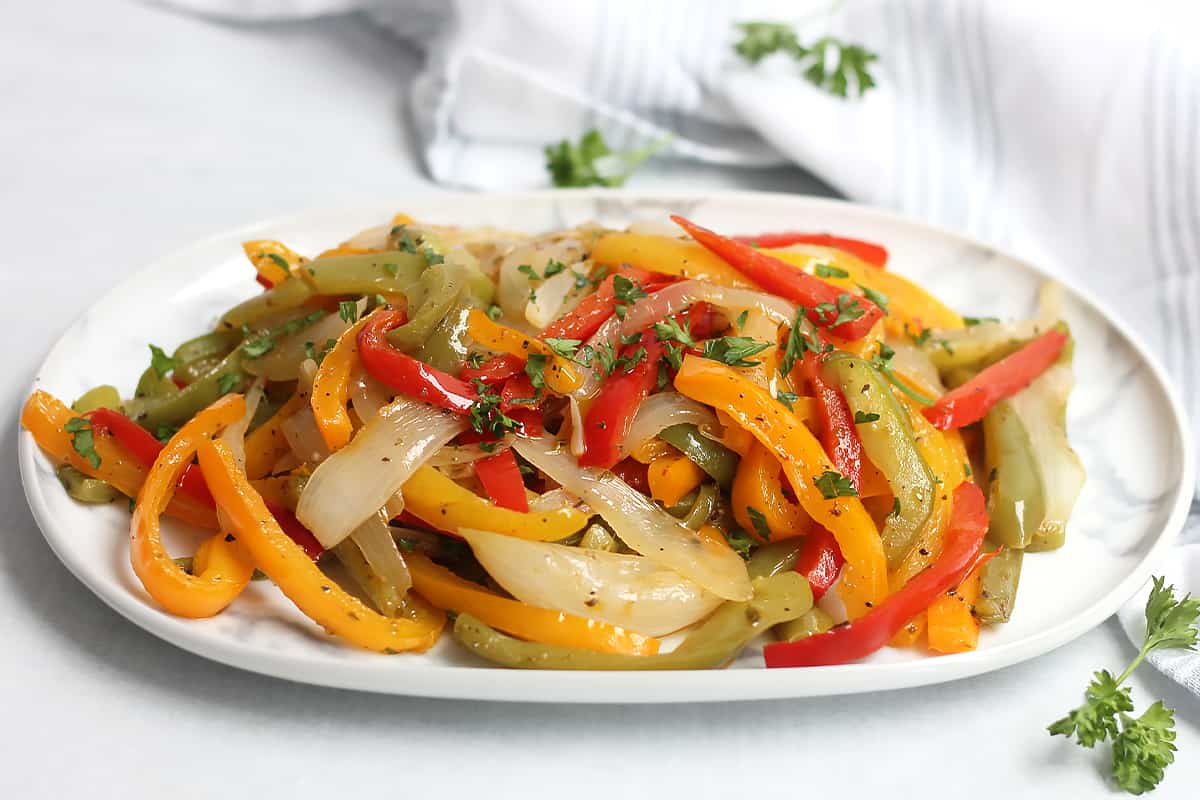 Sliced bell peppers and onions on a serving plate.