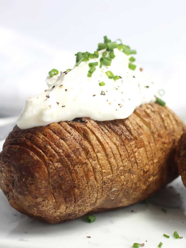 An air fried hasselback potato topped with sour cream and chives.