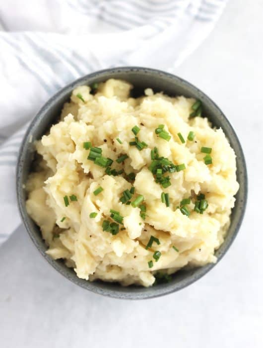 Overhead shot of almond milk mashed potatoes garnished with chopped chives.
