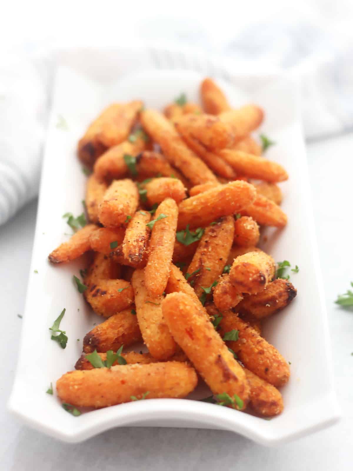 Air fryer baby carrots on a white serving dish.