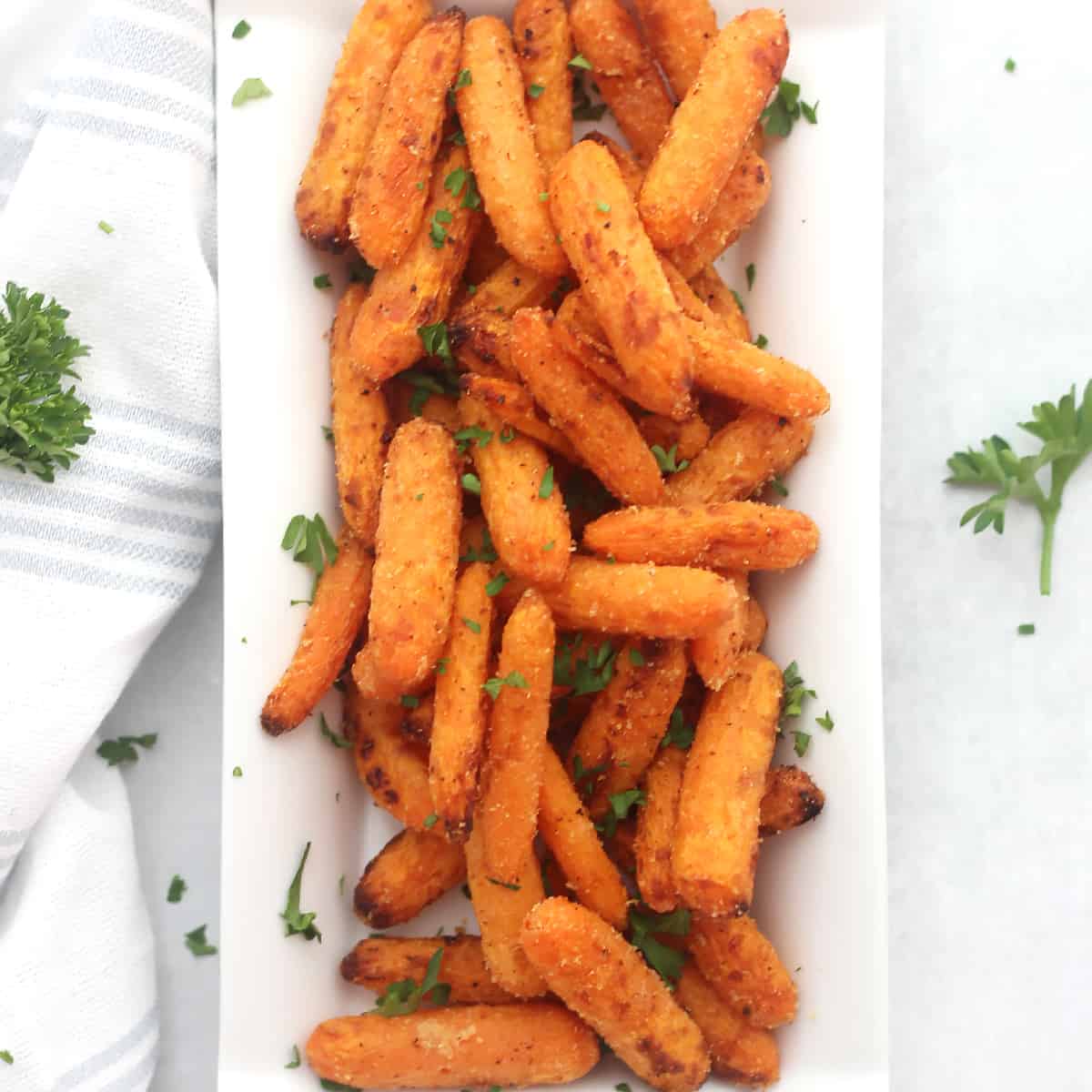 Close of up air fryer baby carrots garnished with fresh parsley.