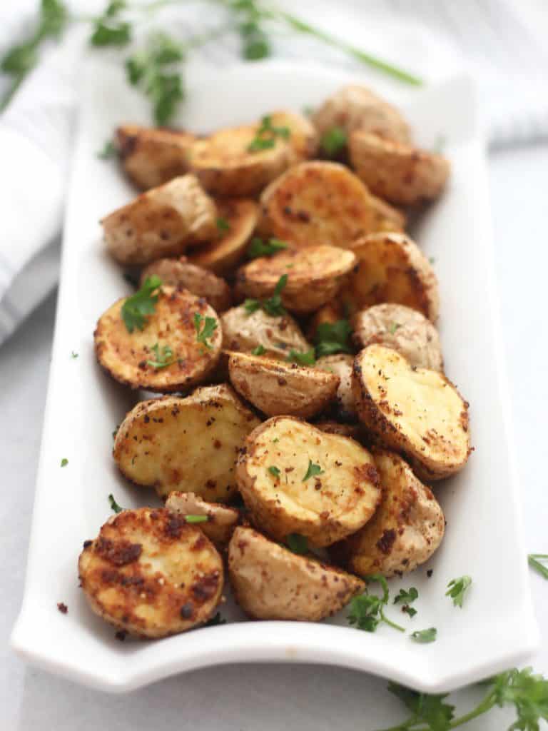 Baby potatoes on a white serving plate.