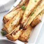 Close up of air fried parsnips on a white serving plate.