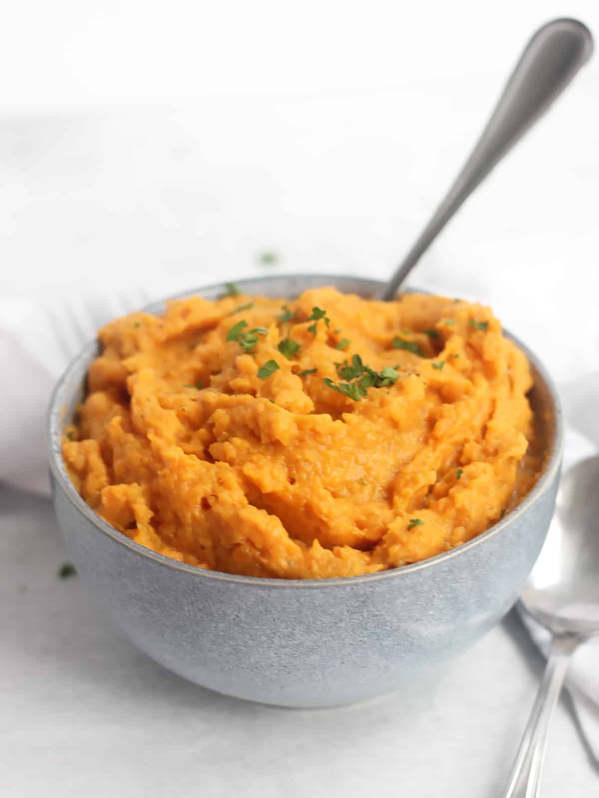 Swhipped sweet potatoes in a bowl with a spoon.