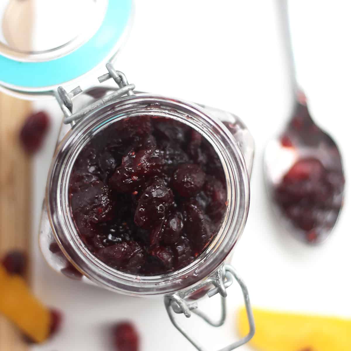 Overhead shot of cranberry sauce in a glass jar.