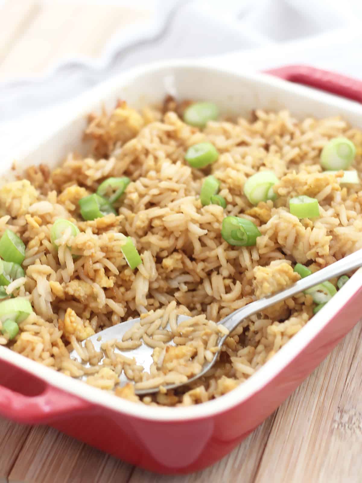 Close p of the fried rice in a baking dish with a spoon.