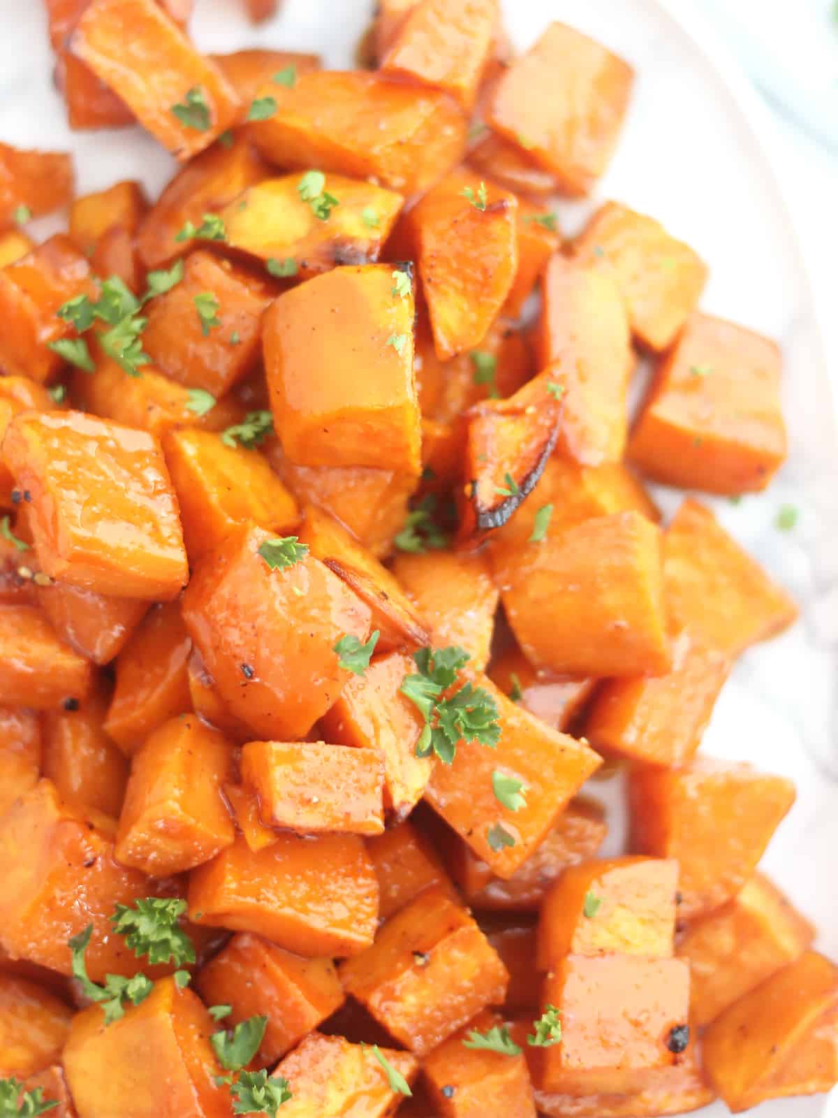 Close of of roasted sweet potato cubes on a plate.