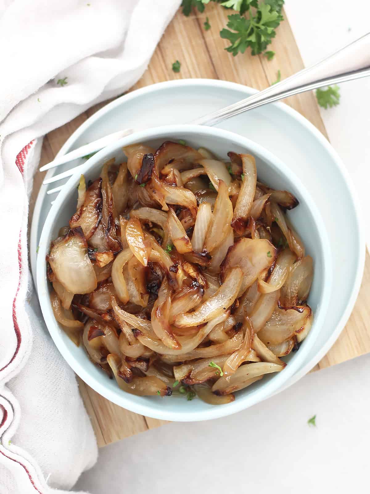 Overhead shot of air fryer caramelized onions in a small serving bowl with a fork.