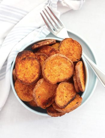 Overjead shot of baked sweet potato slices in a bowl with a fork.