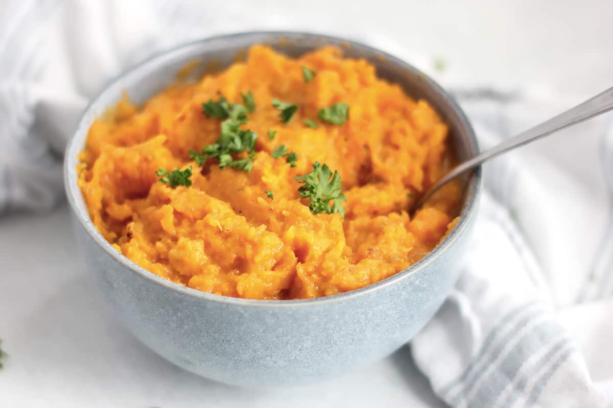 A serving spoon in a bowl of butternut squash mash.