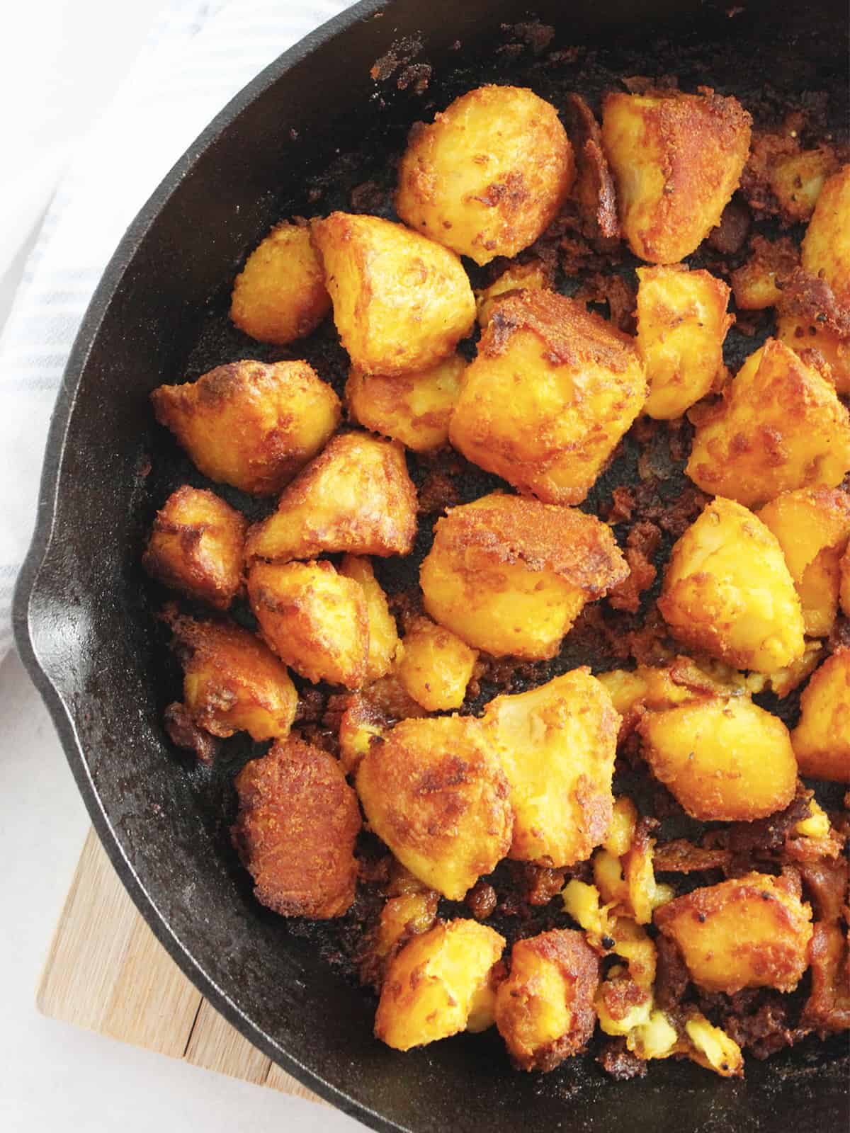 Roasted turmeric potatoes in a cast iron skillet ready to serve.