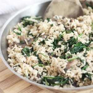 Spinach and mushroom rice in a silver skillet ready to serve..
