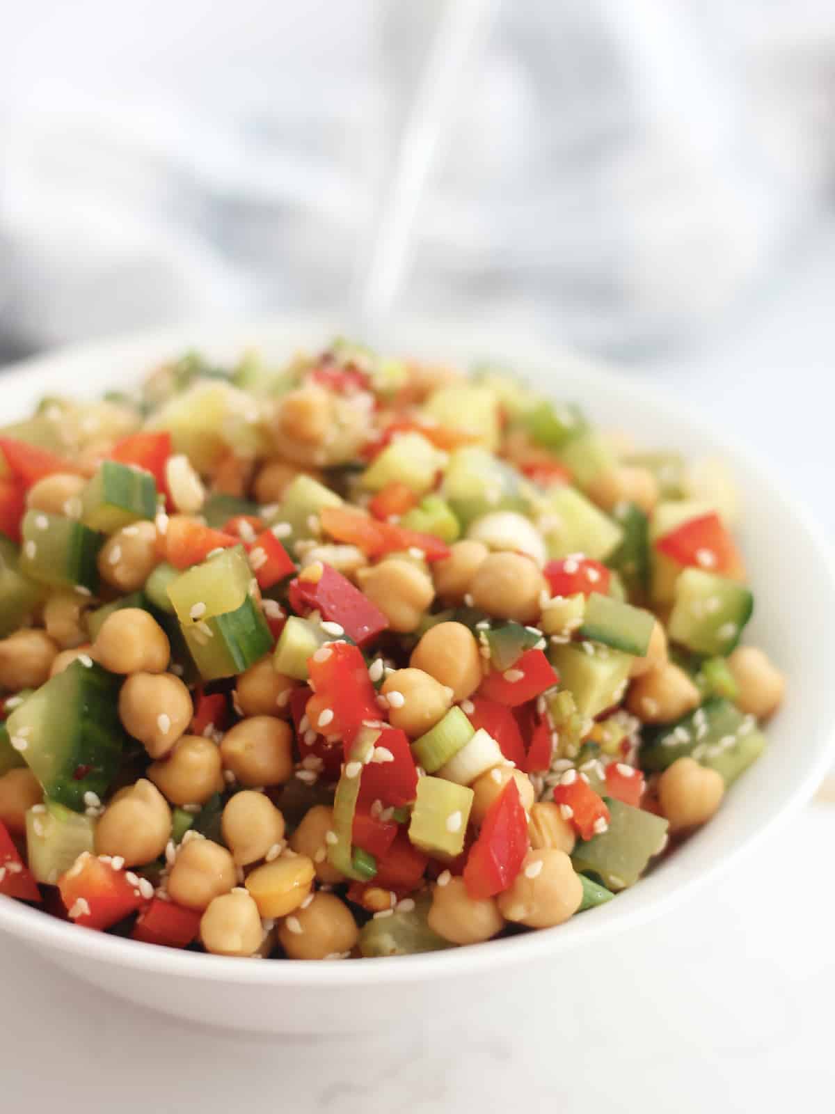 Asian chickpea salad served in a white bowl.