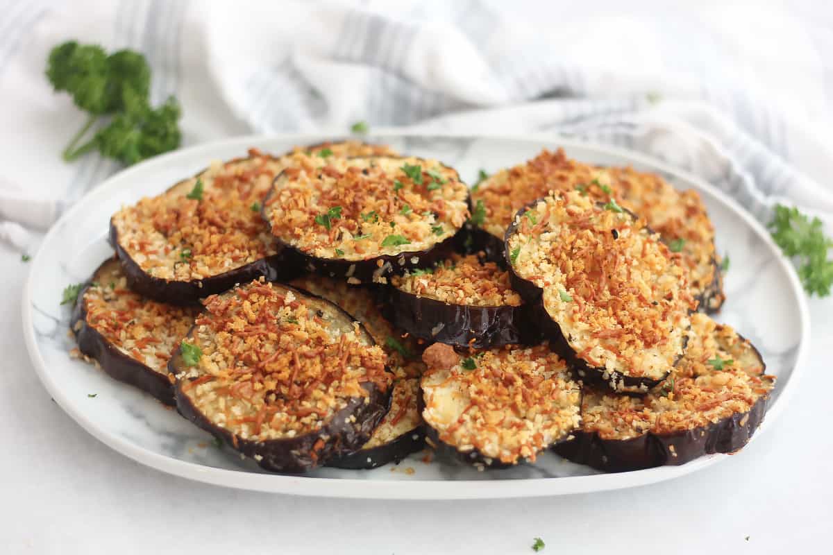 Crispy cheesy eggplant slices on a serving plate.
