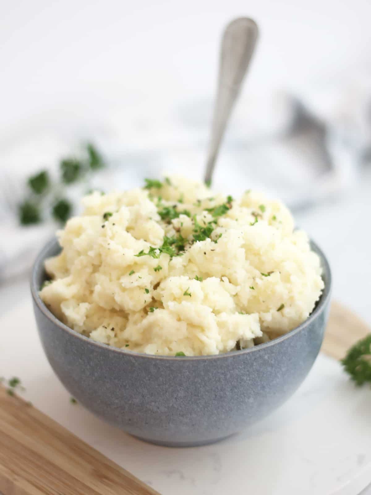 Boursin mashed potatoes in a blue bowl with a spoon.