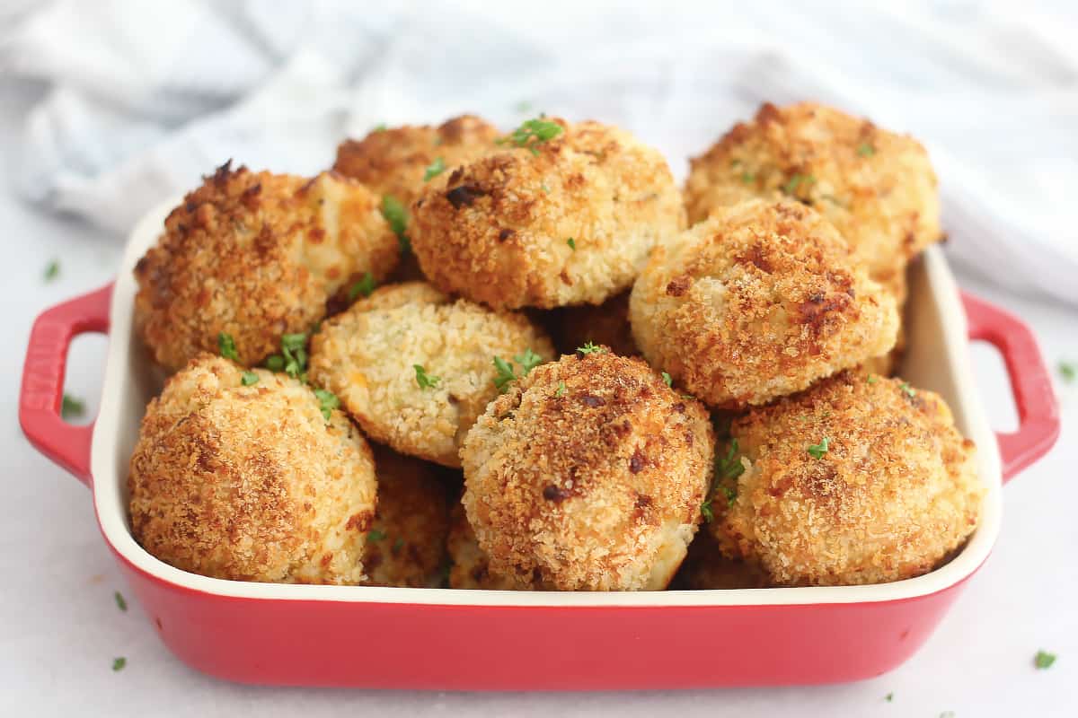 Air fried mashed potato balls in a red serving dish.