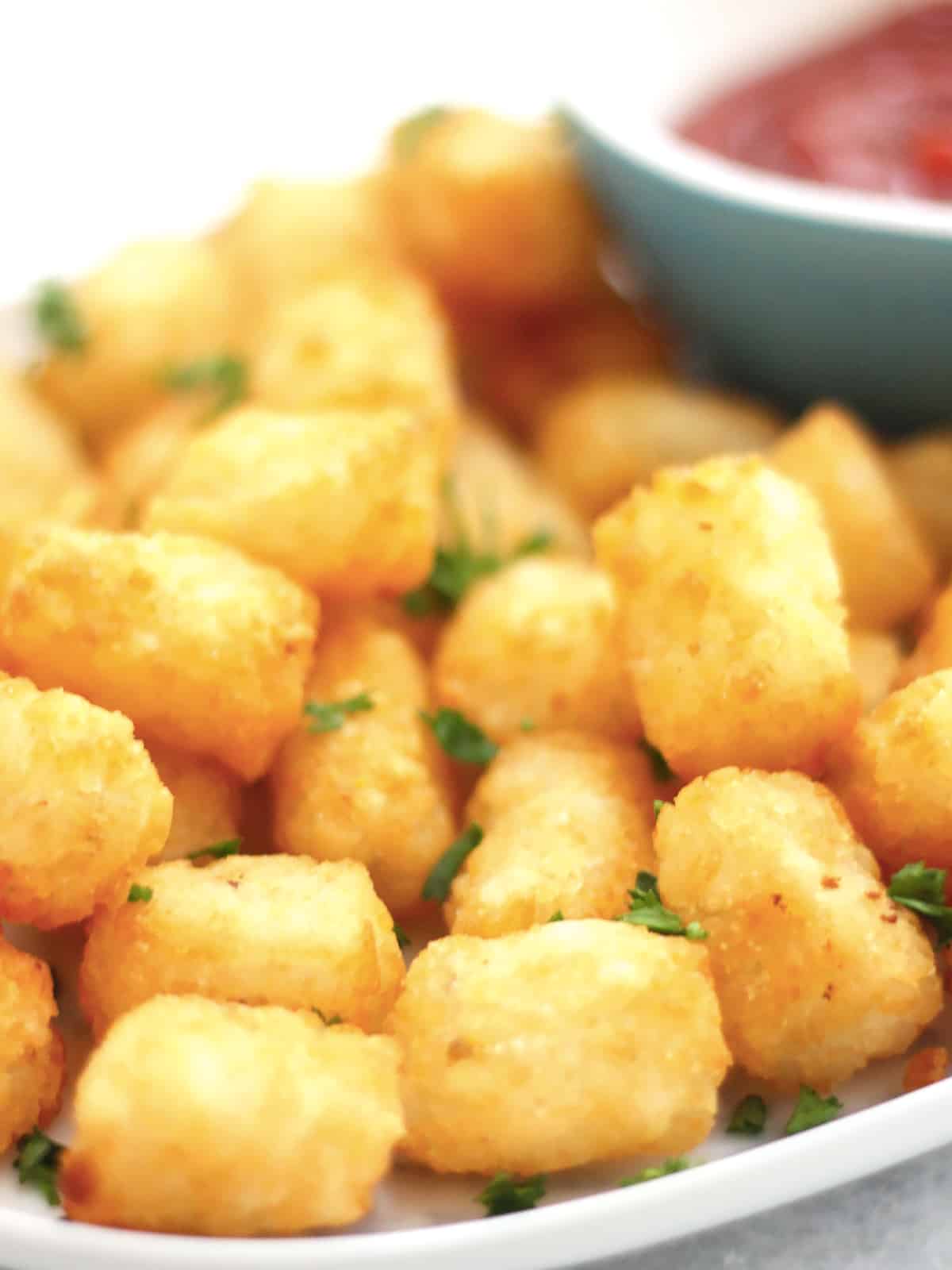 Crispy tater tots on a serving plate.