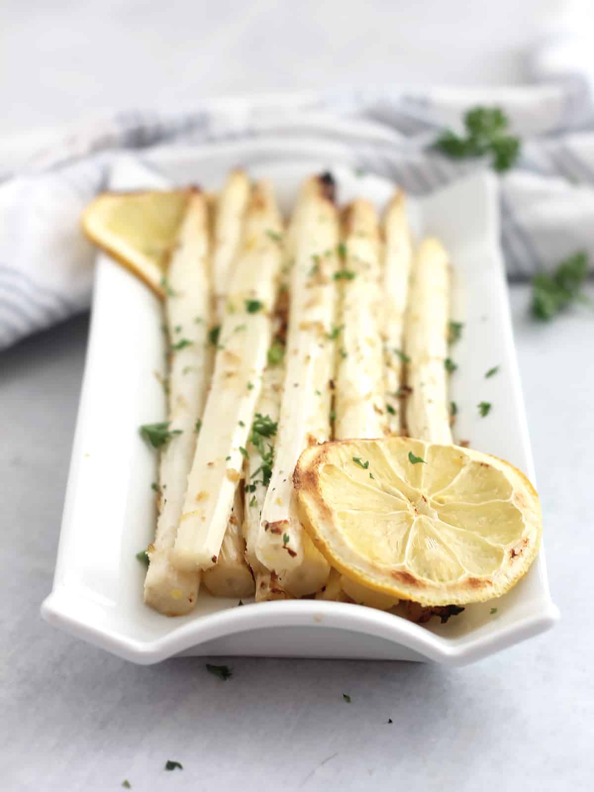 Roasted lemon and white asparagus on a plate.