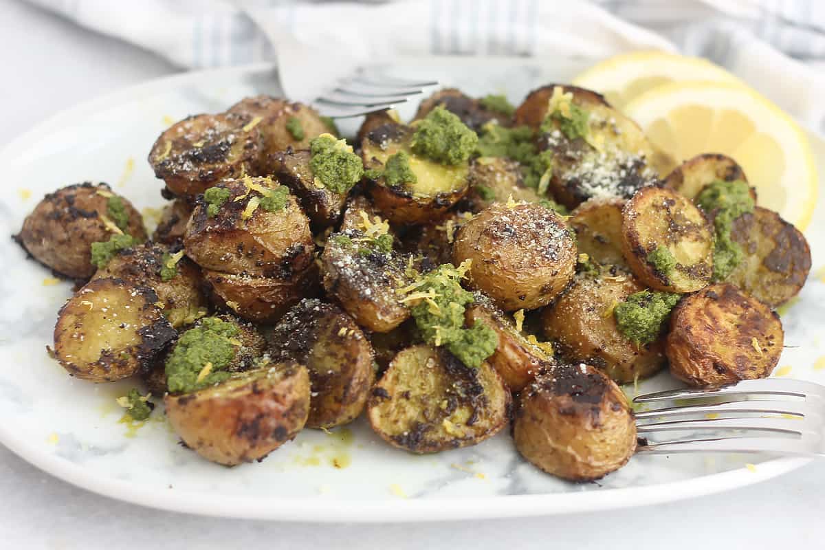 Pesto potatoes garnished with lemon zest and parmesan cheese.