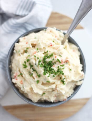 Overhead shot of mashed potato salad in a bowl topped with chopped chives.