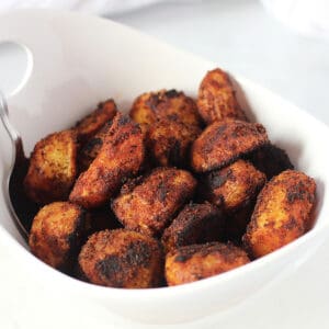 Paprika roasted potatoes in a bowl with a serving spoon.