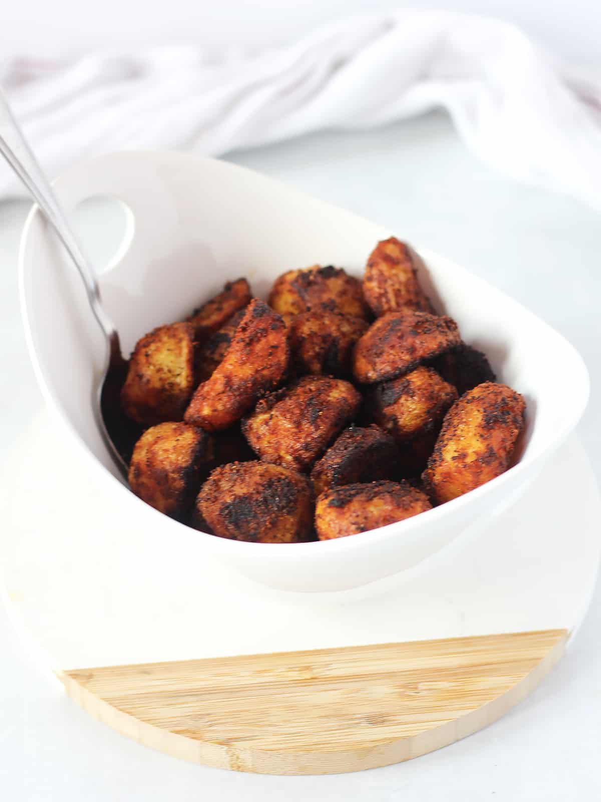 Paprika roasted potatoes in a bowl with a serving spoon.