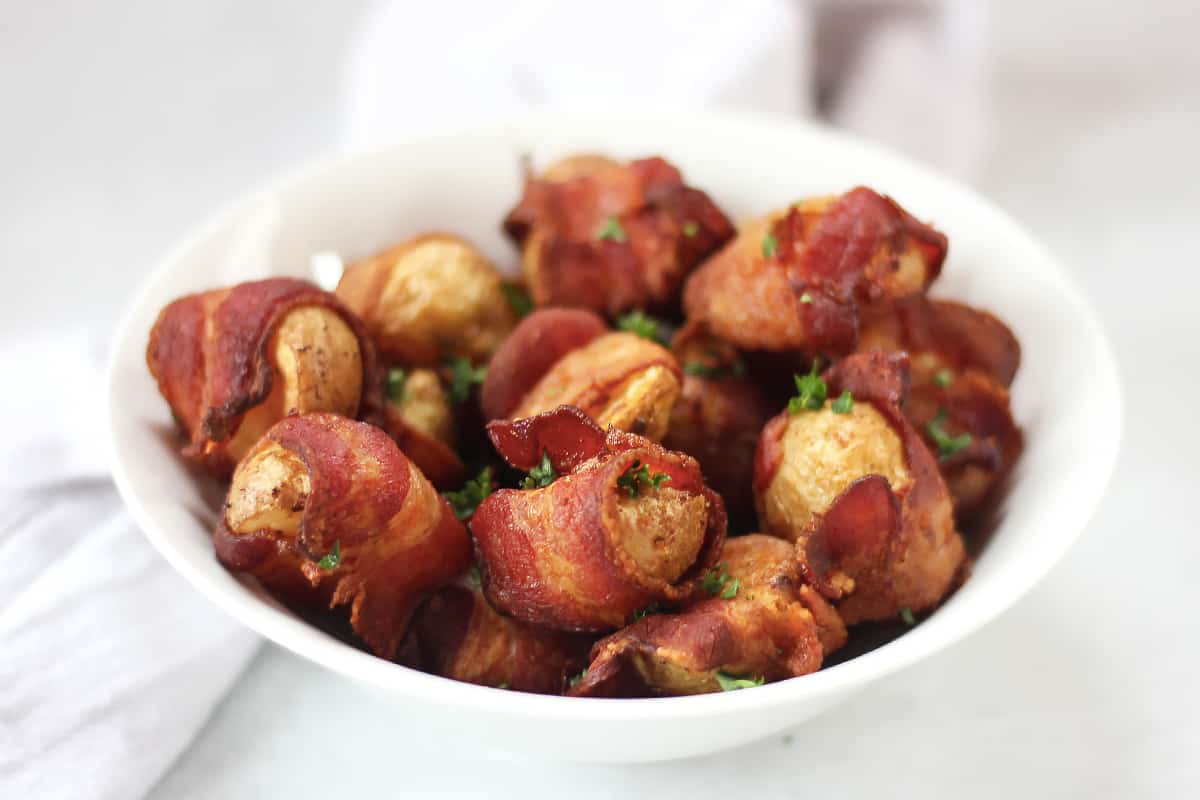 Potatoes wrapped in bacon served in a bowl.