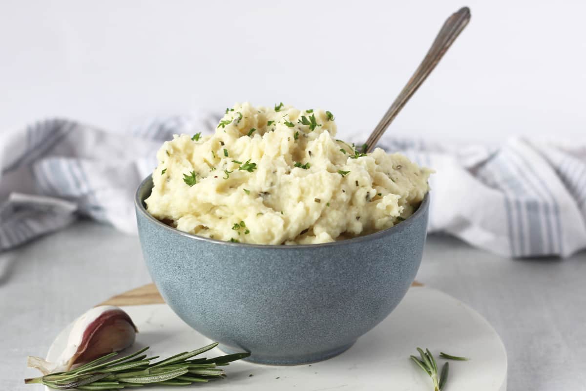 Rosemary garlic mash served in a bowl with a spoon.