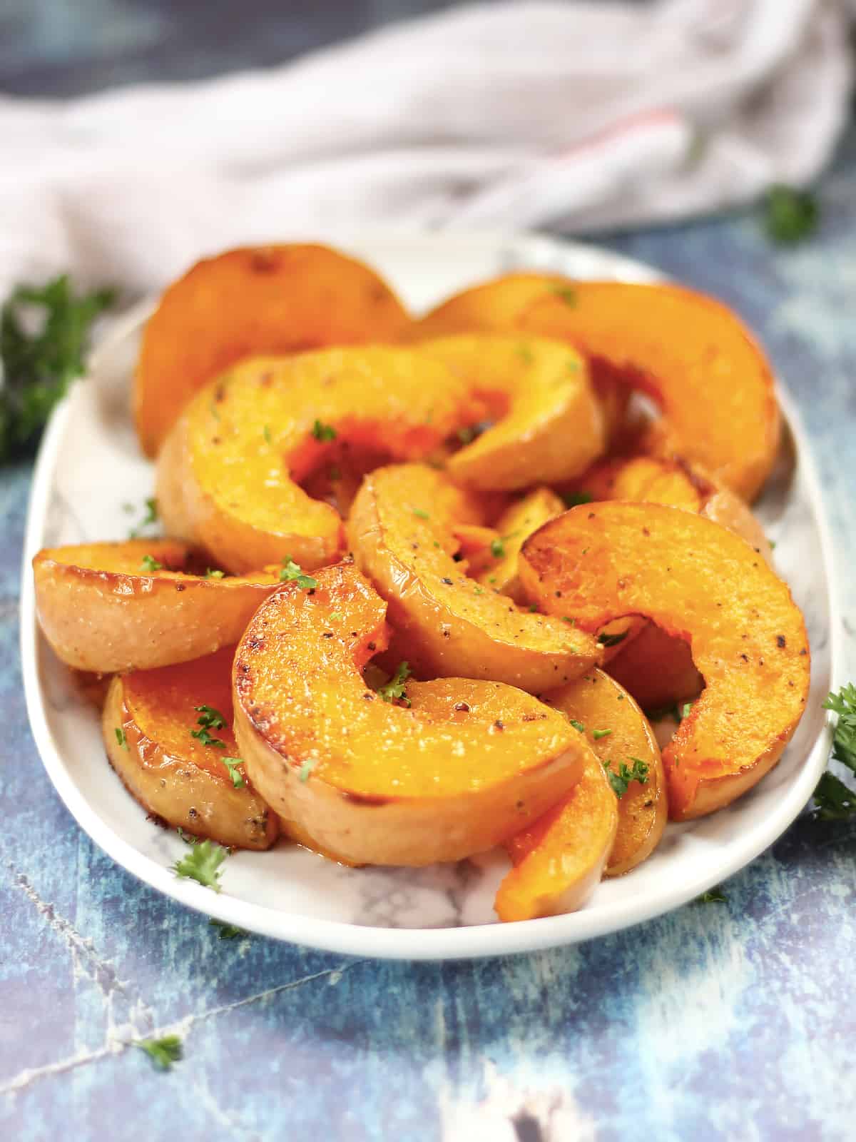 Wedges of roasted butterkin squash on a serving plate.