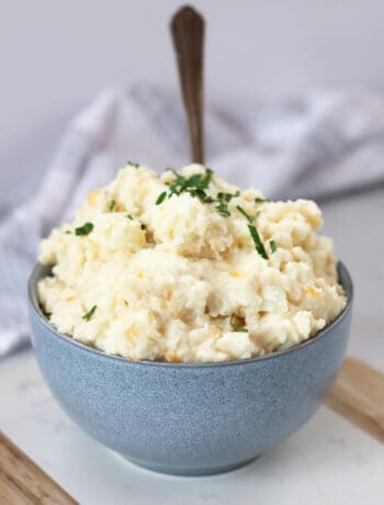 Mashed potato with cheese and garlic in a blue bowl.